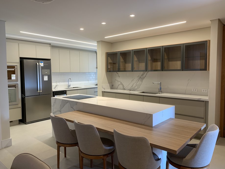 Ilha gourmet para 4 pessoas e cozinha integrada ao living. Piso em porcelanato via durini off white 90x90