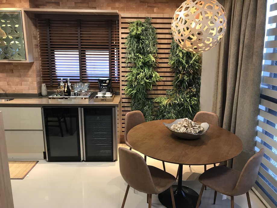 Varanda Gourmet com bar e mesa de refeições.