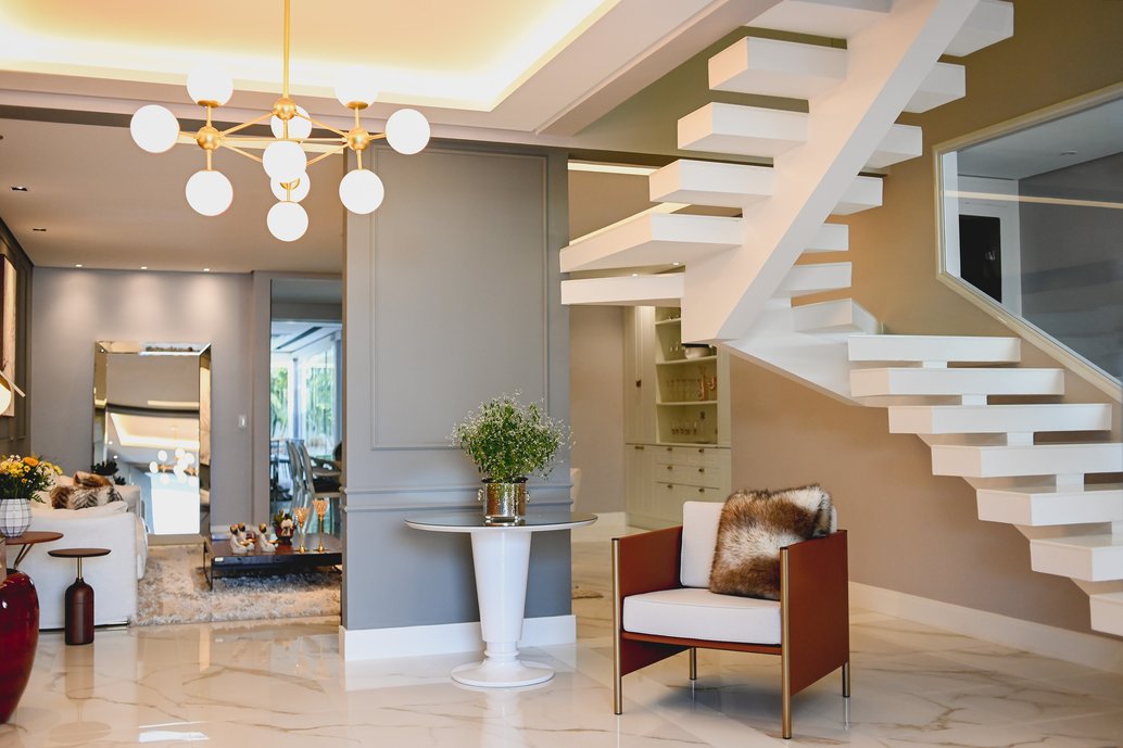 Hall de entrada que integra a casa ao piso superior e demais ambientes da residência.