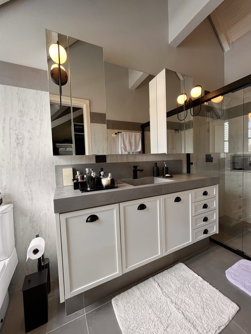 As lastras em Travertino Navona Grigio de formato 90x180 deram o destaque a este banheiro, tendo como acabamento superior o rodapé Superquadra Zinco no formato 20x90