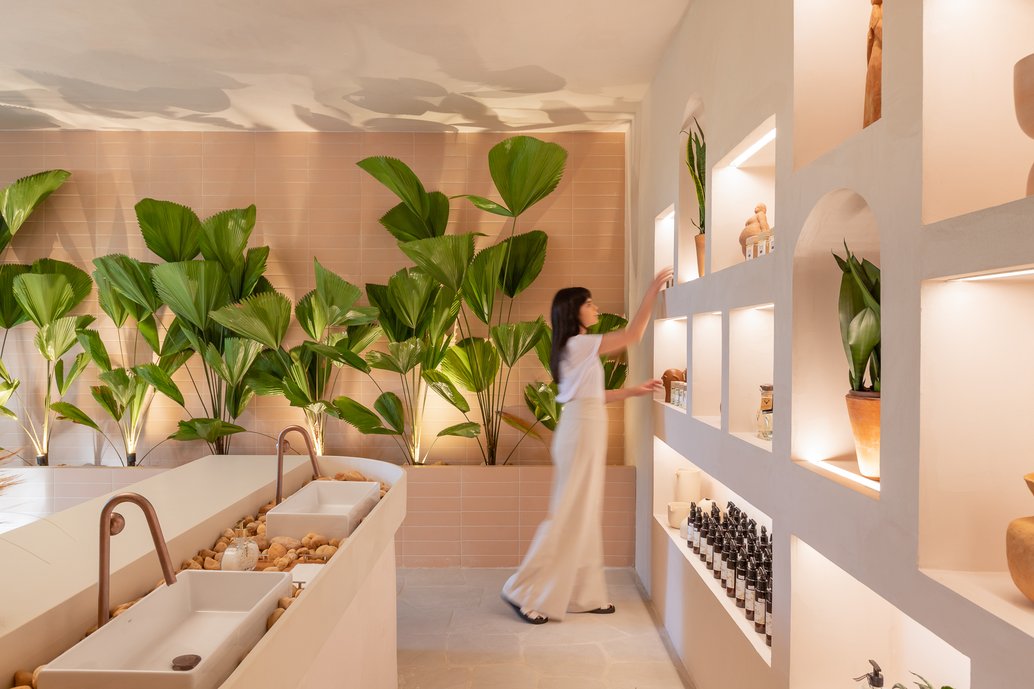 A Casa de Aromas é um projeto comercial realizado para a Casacor Brasília 2021. O conceito do espaço tenta trazer de volta a conexão com a natureza, traduzida nos tons terrosos e nos materiais naturais. Tudo isso realçado pelos cheiros de uma atmosfera relaxante A fachada da Casa de Aromas trás em sua concepção uma forma orgânica, abaulada, que convida o visitante para o interior da loja. A Portobello Shop foi parceira deste projeto, trazendo os revestimentos Kit Janeiro Off White no piso e o Terralma Sardenha na parede lateral compondo o jardim. 