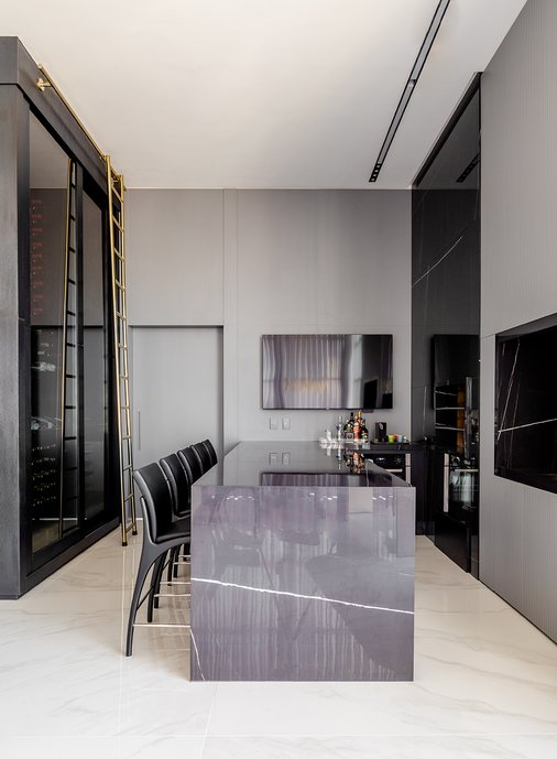 Área de lazer com Lastras de Bianco Covelano aplicadas no piso, constrastando com Black Eclipse na churrasqueira, bancada e nicho. 