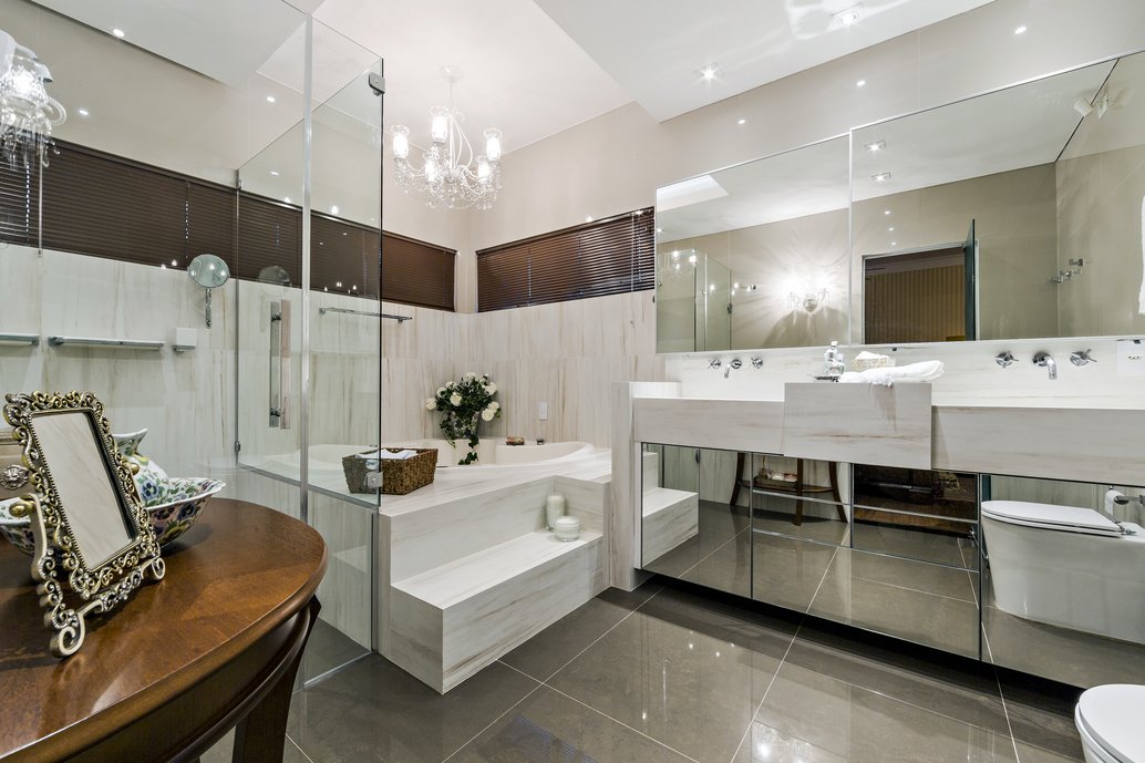  SALA DE BANHO COM BANHEIRA E PIA ESCULPIDAS EM PORCELANATO. 