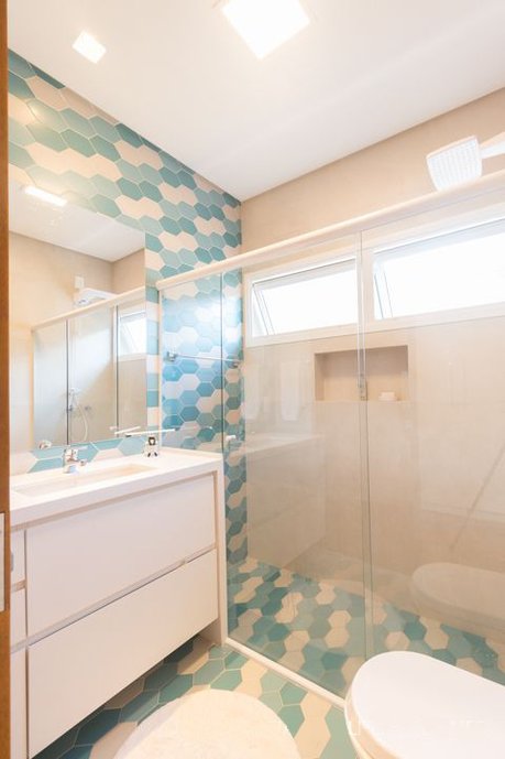 Foto: Guilherme Gomes. Composição com Chez Moi em tons azuis e off white em uma parede principal e também no chão do banheiro do menino, e no restante das paredes o Pietra de Firenze Nude como base neutra.