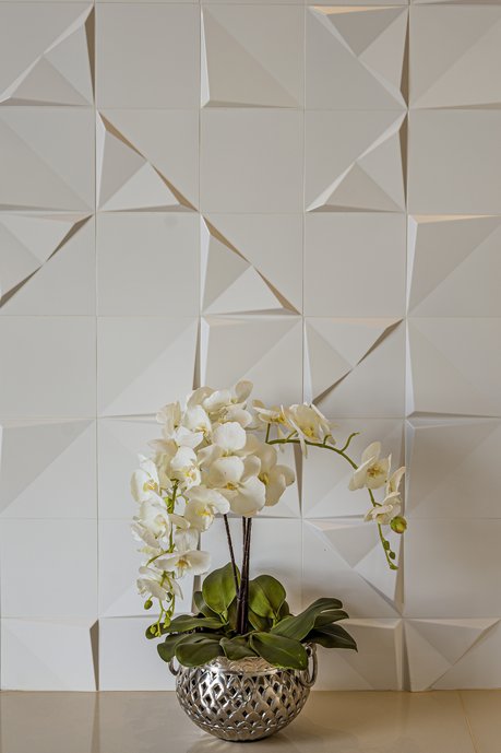 Detalhe da parede no Tangram Branco. Jarro com orquídea.