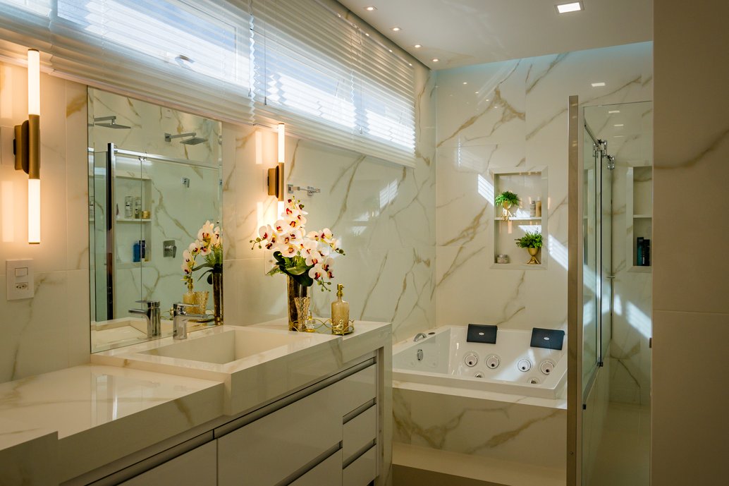 Banheiro todo revestido no Oro Bianco e com bancada esculpida no mesmo material.