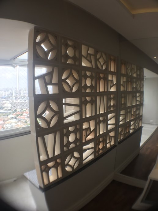 Parede de elementos vazados delimita o espaço do jardim de inverno mantendo a iluminação natural na sala