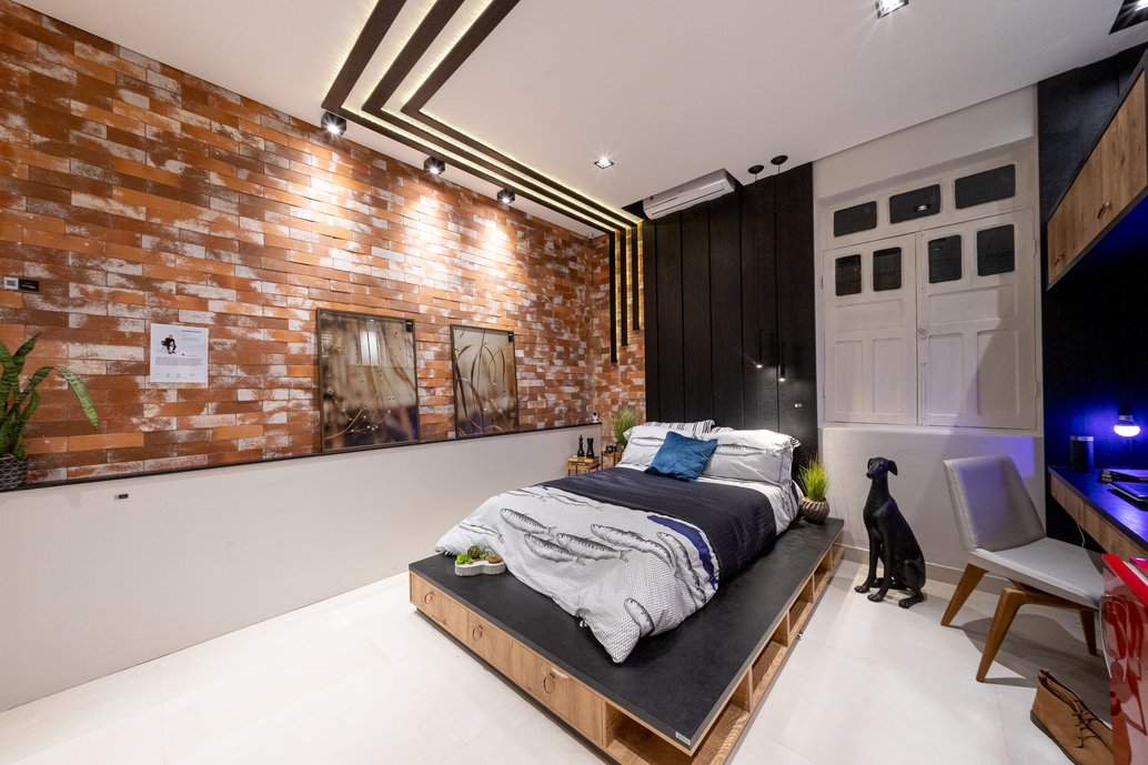 Quarto estilo urbano, contemporâneo. Cama com base planejada de madeira, guarda-roupa aberto.