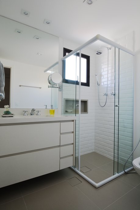 Banheiro para Sala de Tv / Dorm. Hóspedest. A escolha do revestimento Liverpool White e do piso City Cement, traz neutralidade e delicadeza. O nicho que também segue a mesma cor do piso traz o contraste com o branco deixando o ambiente sofisticado.