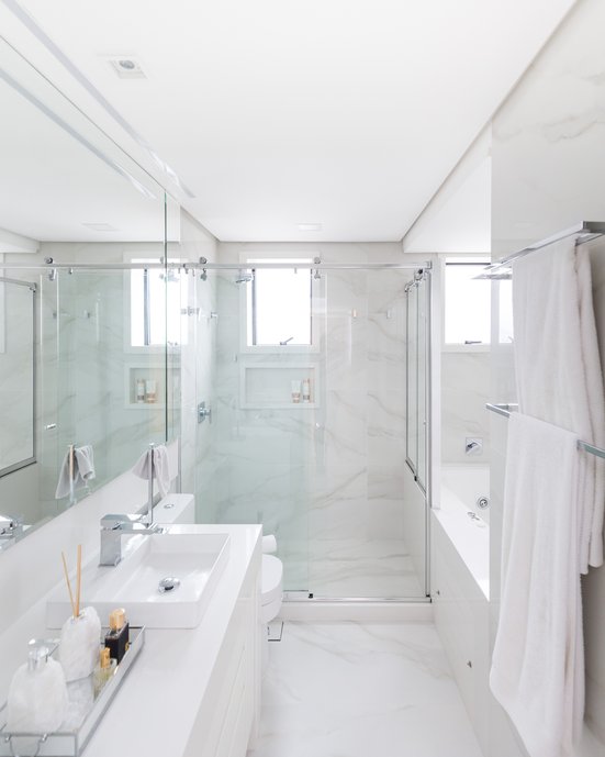 Banho elegante do casal, com tons claros que conferem leveza visual ao ambiente. A banheira de hidromassagem com cromoterapia é o ponto alto do banho relaxante. Optamos por utilizar o mesmo revestimento no piso e nas paredes, pois tanto o cliente quanto nós, gostamos dessa unidade visual. Foto: Marcelo Donadussi