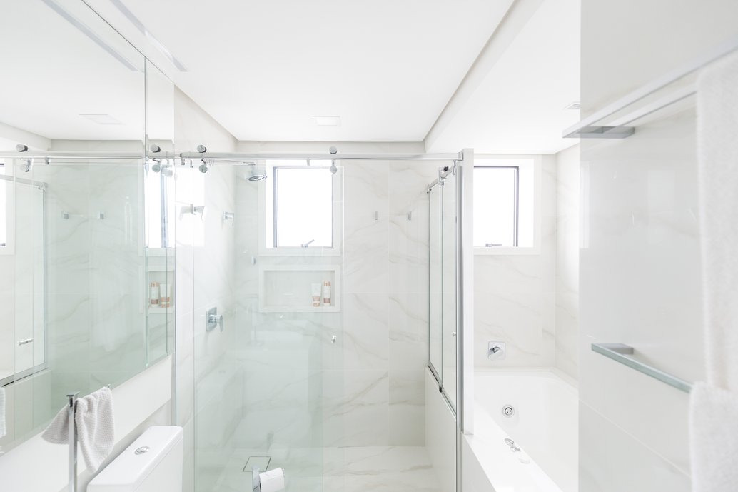 Banho elegante do casal, com tons claros que conferem leveza visual ao ambiente. A banheira de hidromassagem com cromoterapia é o ponto alto do banho relaxante. Optamos por utilizar o mesmo revestimento no piso e nas paredes, pois tanto o cliente quanto nós, gostamos dessa unidade visual. Foto: Marcelo Donadussi