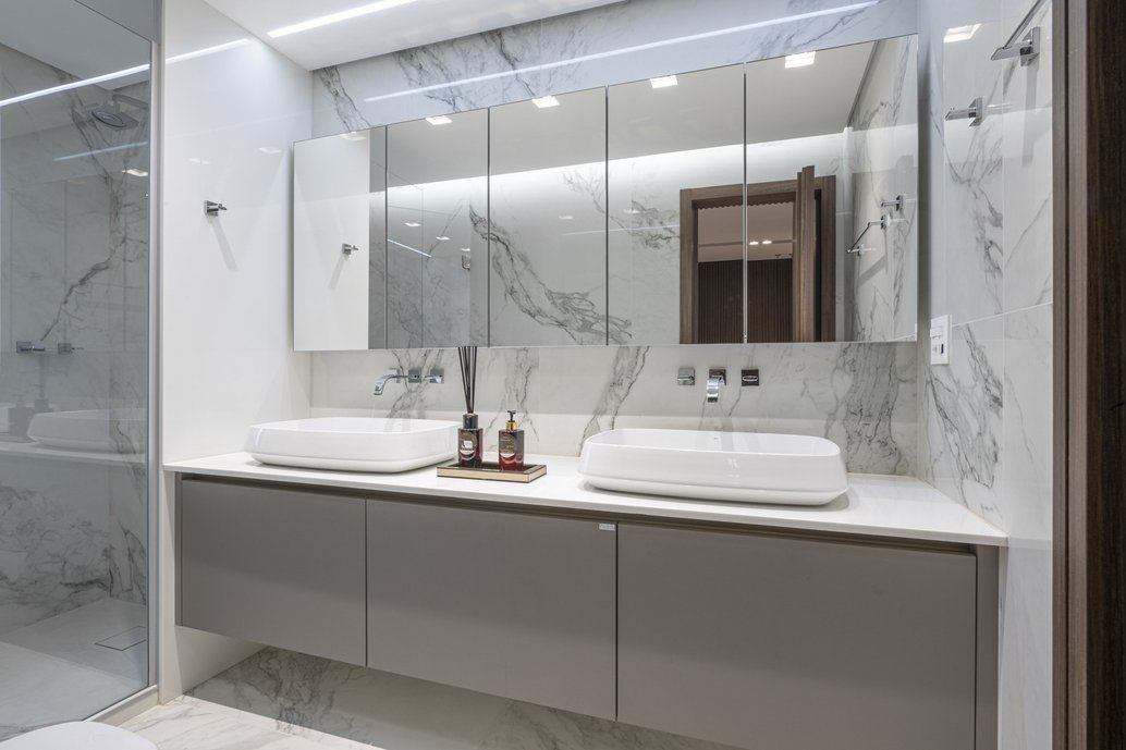 Banheiro inteiro em porcelanato Bianco di Elba da Portobello, bancadas em supernanoglass e cubas Jader Almeida para Deca. 