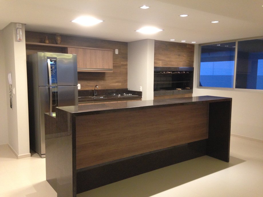 Área gourmet com revestimento em porcelanato Imbuia Clara.