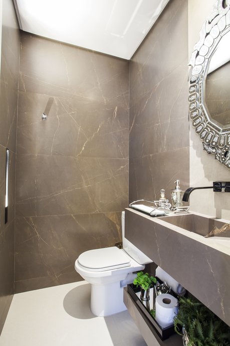 Lavabo com paredes revestidas em porcelanato 60x120 - Bronze Armani fosco. Cuba esculpida com o mesmo porcelanato, executada pela Officina Portobello.