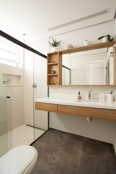 Banheiro Suite. Bancada em branco absoluto, Marcenaria em Freijó e piso Portobello Concreto