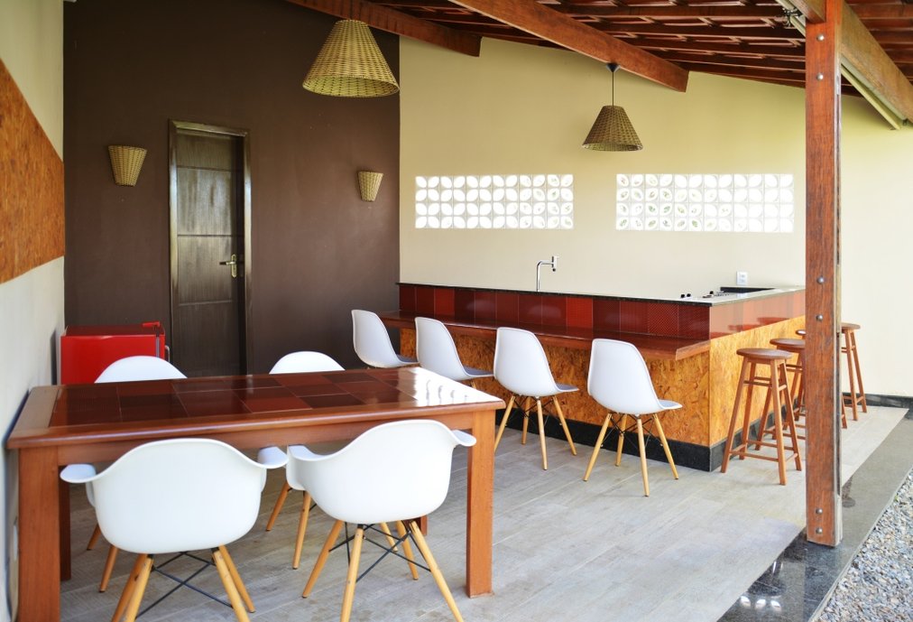 Nesta área gourmet utilizamos o Ferrugem da linha Liberty na mesa de madeira, ele funcionou como tampo, acrescentando um diferencial ao ambiente, que utilizou tons neutros com o vermelho como contraste.