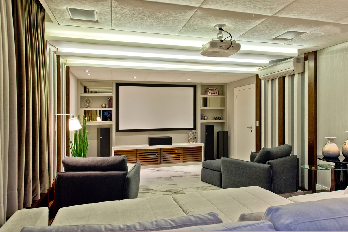 Home theater com paredes e o teto estofados para melhorar a acústica do ambiente. Porcelanato: Bianco Paonazzetto.
