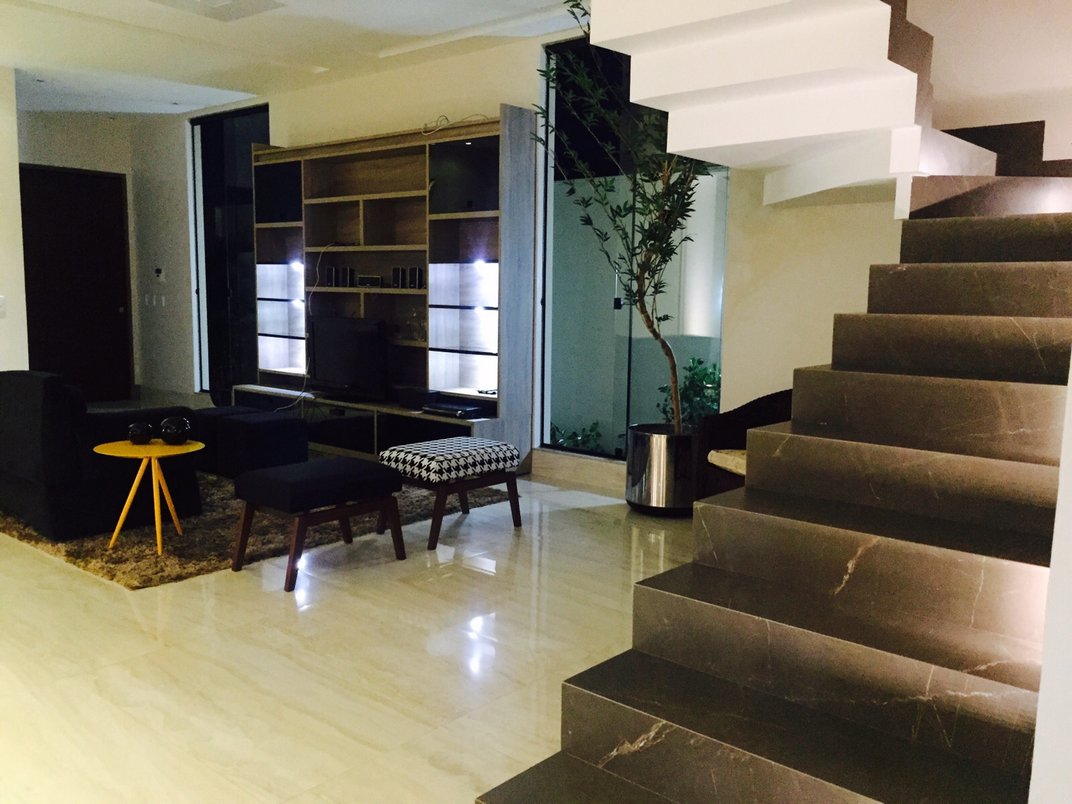 Sala de estar, com piso polido Travertino Navona Bianco 60x120 pol com escada em Bronze Armani 60x120 nat, decorado pela Arquiteta Sheila Pinheiro de Araguaína.