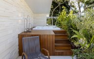 Área de descanso, com spa e vegetação tropical.