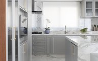 Cozinha com estilo clássico, bancadas e ilha esculpida em porcelanato.