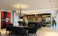 Sala de jantar integrada com churrasqueira e espaço gourmet.